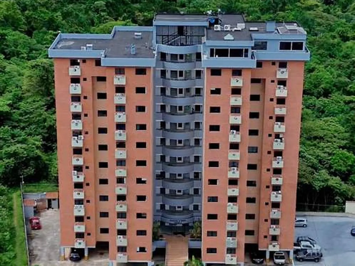 Edificio residencial de ladrillo rodeado de árboles, en La Castellana de San Cristóbal